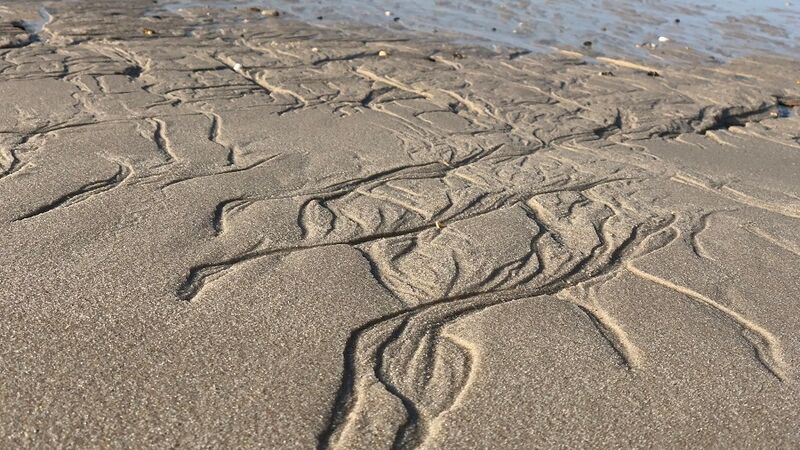 Strand bei ablaufendem Meer mit Mustern im Sand